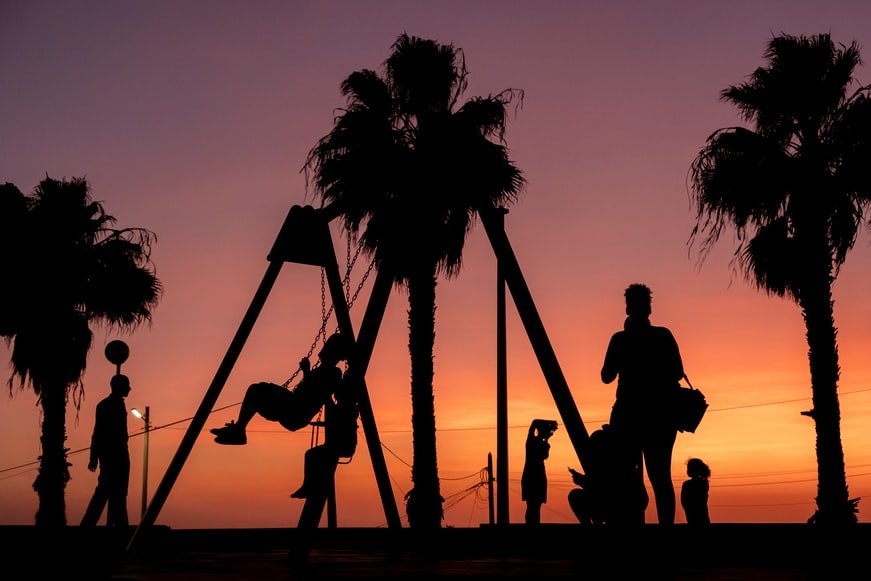 Image of People on a playground during sunset.