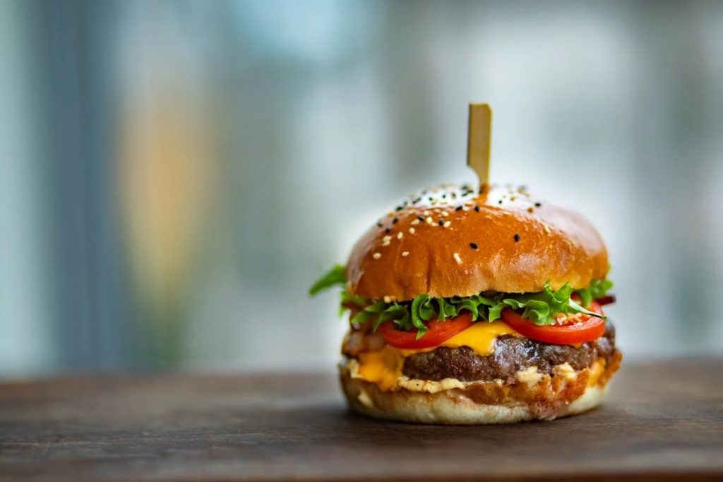 Image of Photo of Juicy Burger on Wooden Surface