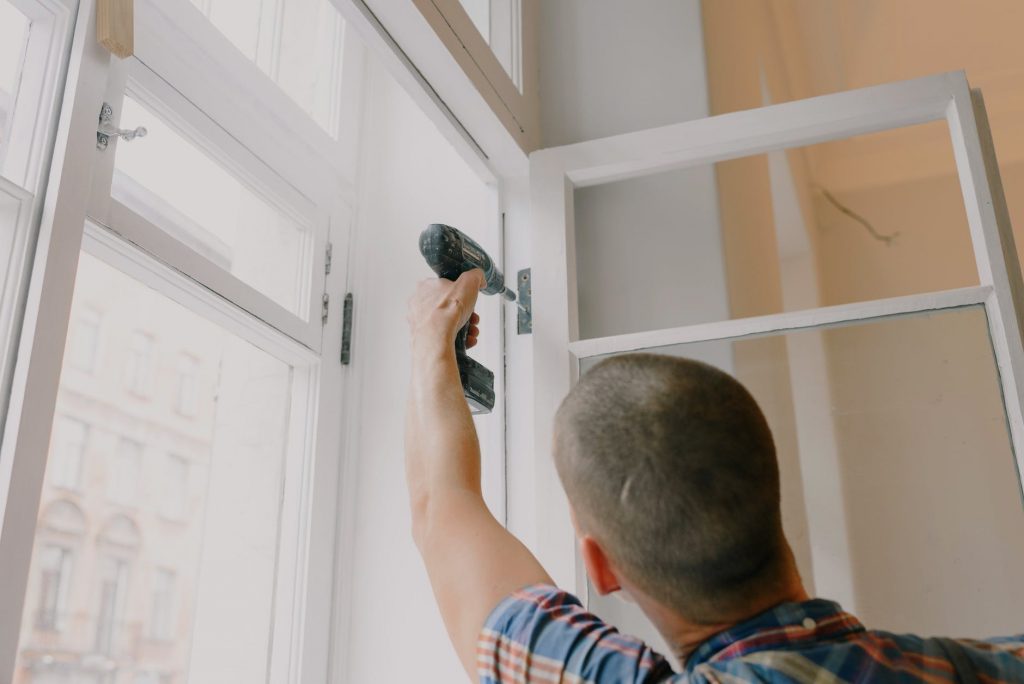 Image of Anonymous man installing window in room