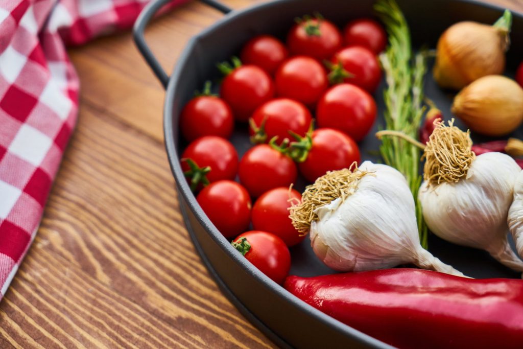Image of Red Tomatoes and Garlics in Cooking Pot
