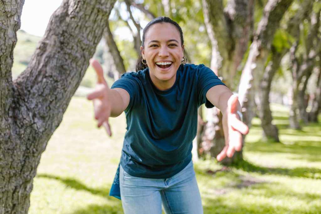 Image of Smiling Woman in Blue Crew Neck T-shirt With Open Arms