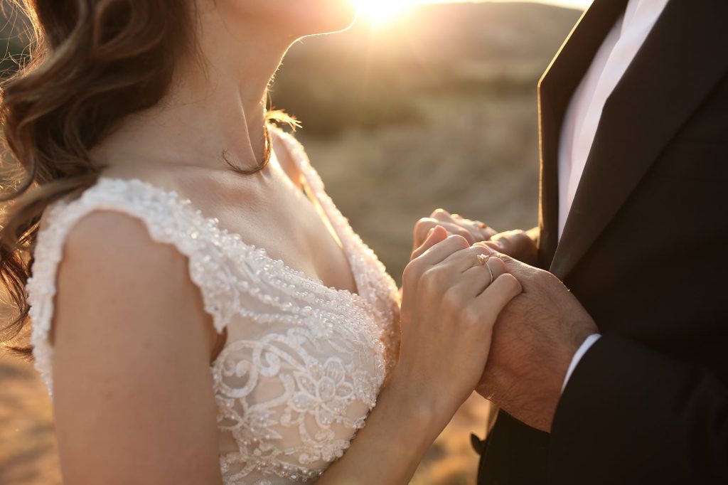 Image of Bride and Groom Holding Hands at Sunrise