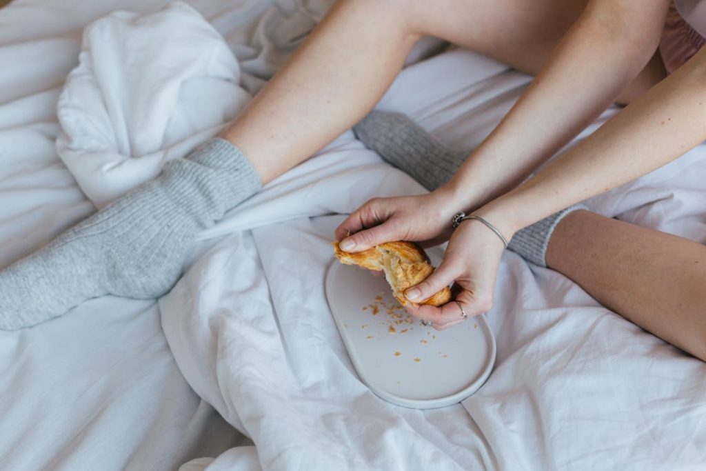 Image of eating croissant on comfy bed at home