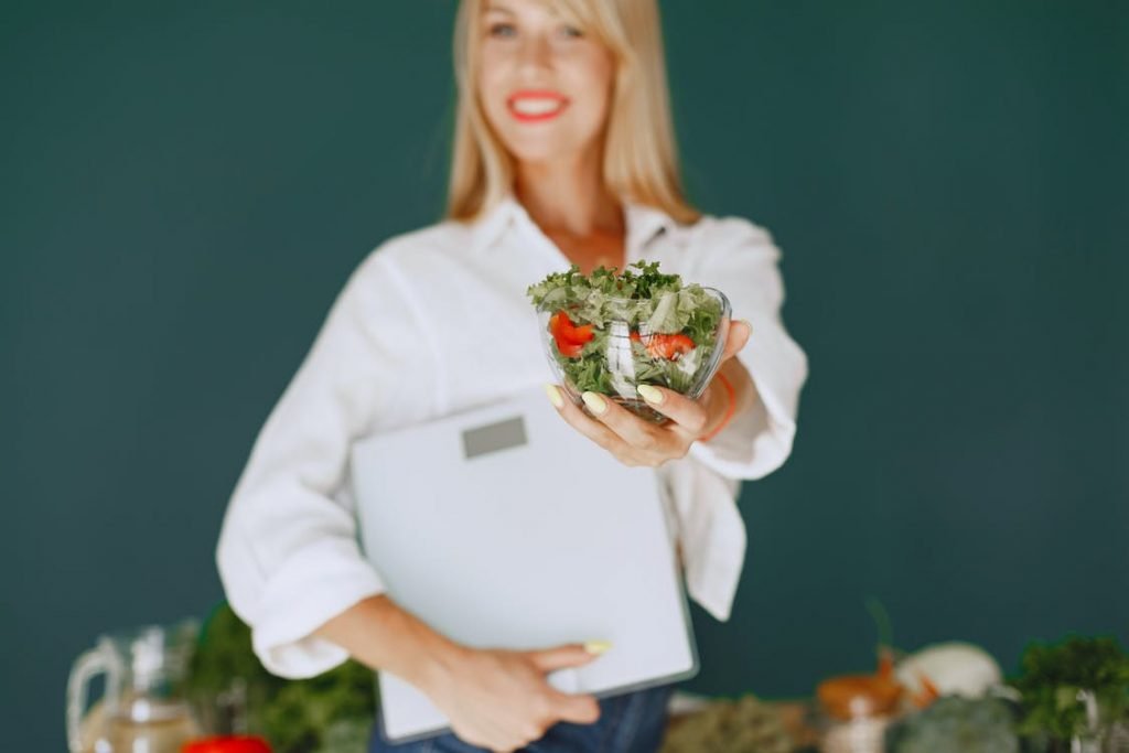 Image of Woman Holding a Bowl with Salad and Smiling